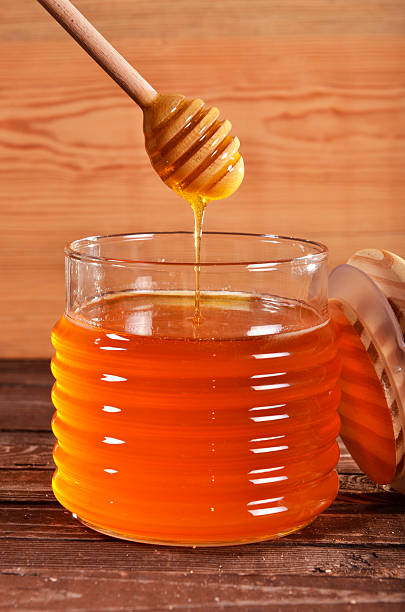istock Jar of honey on a wooden background 467841413