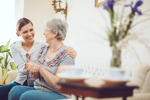 latin trabajador social está de visita en una mujer mayor - senior living communitiy fotografías e imágenes de stock