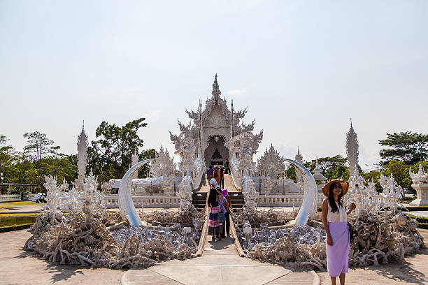Chiang Rai, Thailand - May 5, 2013: Worshipers who in front of the White temple named Wat Rong Khun in Chiang Rai, Thailand.