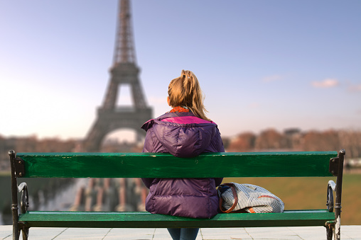 Lonesome girl watching at Paris city scape at sunset.