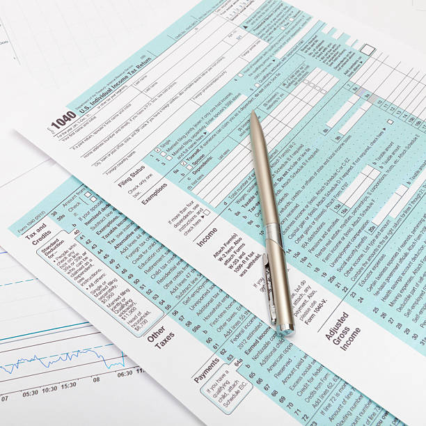 istock US 1040 Tax Form and silver ball pen over it 467850034