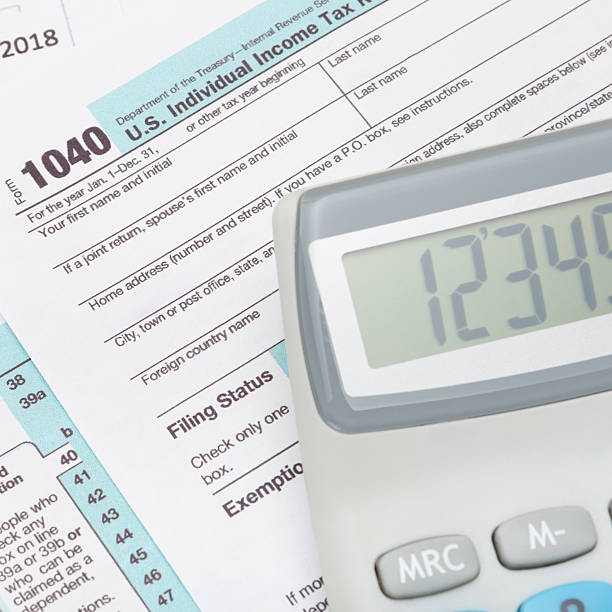istock Calculator over US 1040 Tax Form - studio shot 467850044