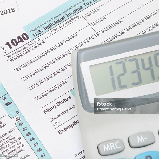 Calculator Over Us 1040 Tax Form Studio Shot Stock Photo - Download Image Now - 1040 Tax Form, 2015, Balance