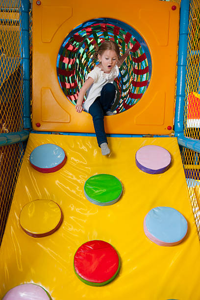 istock Young girl climbing down ramp in soft play centre 467852473