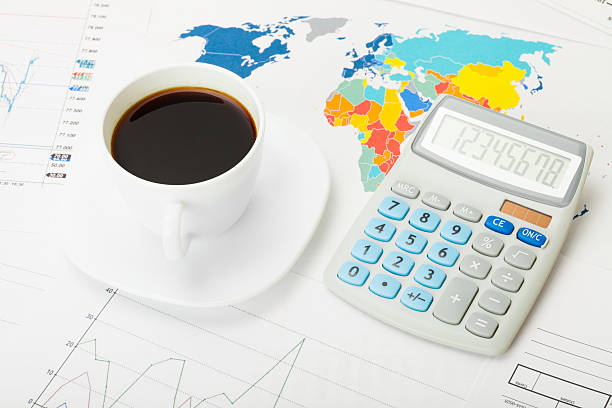 istock Coffee cup over world map and financial charts 467858876