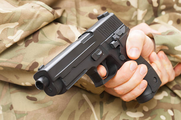 istock Man in black mask holding gun behind his back 467858890