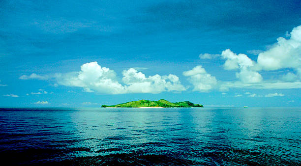Tropical Island Of Fiji A scan from a negative captured in 2003, this is a small tropical island lying in the waters around the island of Taveuni. This area is known as the Somosomo Strait, and is a corridor of water that separates Taveuni from the larger island of Vanua Levu. The soft corals found here make it popular with divers. taveuni stock pictures, royalty-free photos & images