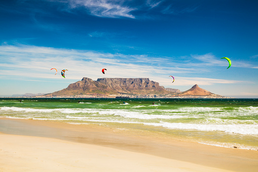 Group of kiteboarders in front of Table Mountain and Cape Town in South Africa.