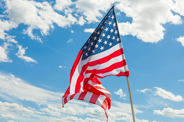 istock USA flag with clouds on background - outdoors shoot 467865946