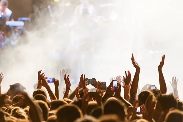 Photo of People taking photographs with touch smart phone during a music