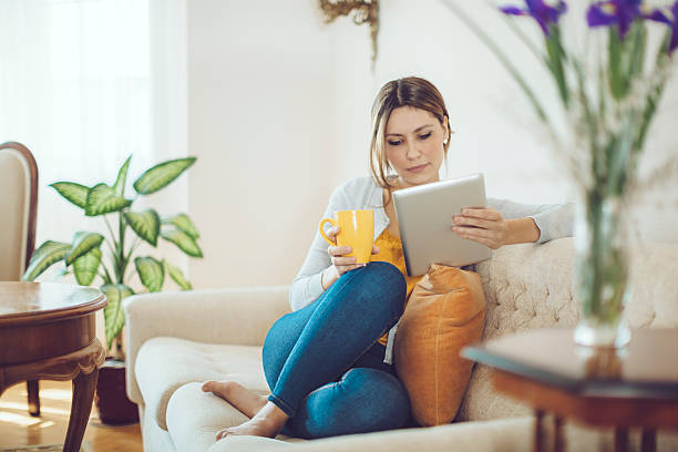 istock Latin woman drinking coffee and reading a tablet 467867570