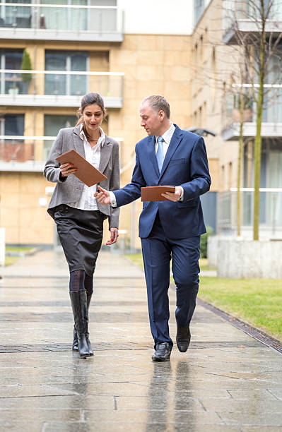 istock Two business people walking and discussing 467870360