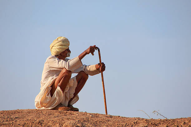 Khichan, India - February 12, 2011: Local man sitting on a hill, Khichan village, Rajasthan, India