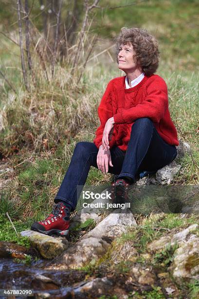 Natural Mature Woman Relaxed And Smiling Outdoors By Stream Stock Photo - Download Image Now