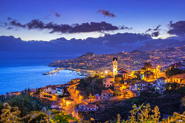 Night view on Funchal on Madeira Elevated view on the district of São Gonçalo and the cityscape, harbour and surrounding mountains of Funchal on the Portugese Island of Madeira. funchal stock pictures, royalty-free photos & images