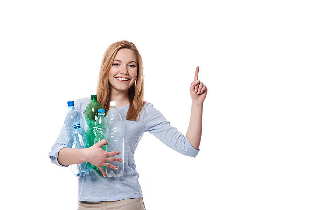 istock Woman with stack of plastic bottles pointing at copy space 467893252