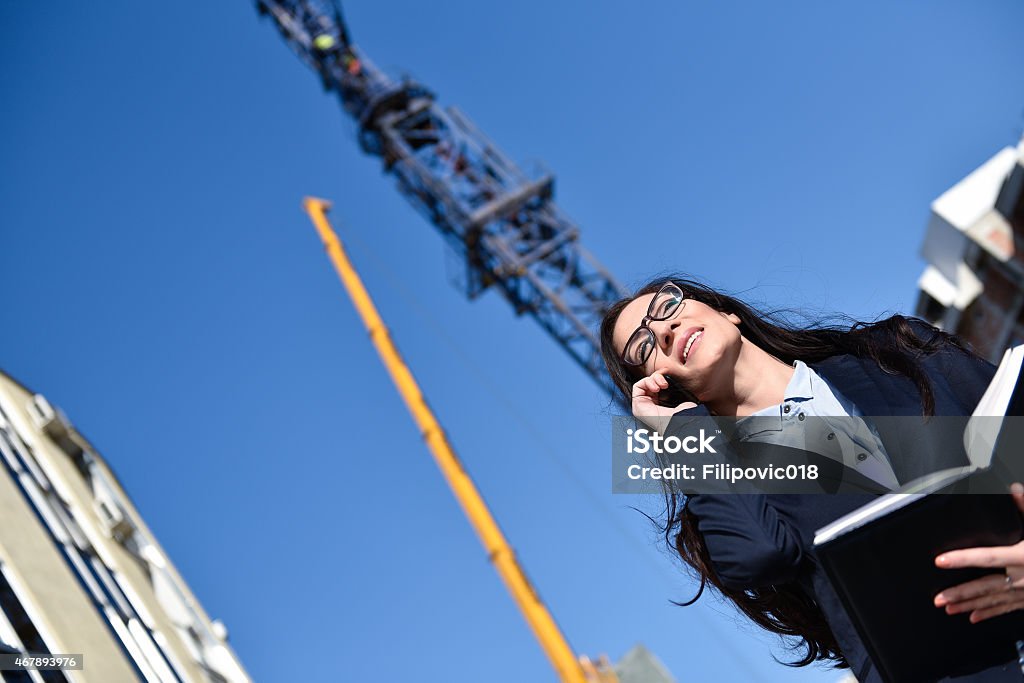 Young Woman Architect Young project leader at the building site telephoning. 2015 Stock Photo