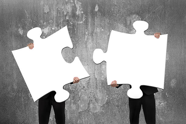 istock Two business people assembling white jigsaw puzzles with concret 467898452
