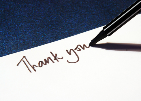 thank you message handwritten on white paper