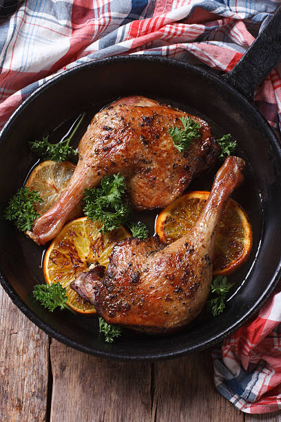 istock Roast duck leg with oranges and parsley vertical top view 467902504