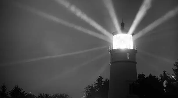 Photo of Lighthouse Beams From Lens Rainy Night Pillars of Light