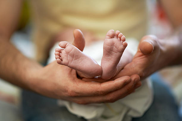 istock Dad holds in his hands  small baby foot 467903580