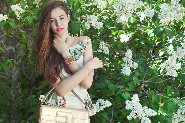 istock Beautiful young girl model posing near blooming lilacs at spring 467905714