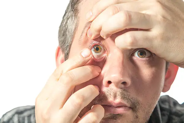 Picture of a man putting on a contact lens