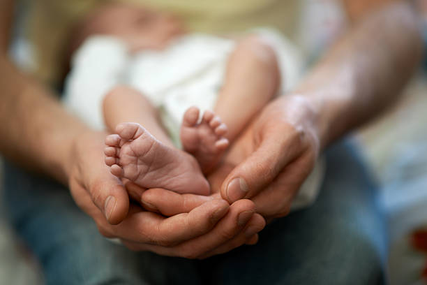 istock Dad holds in his hands  small baby foot 467906572