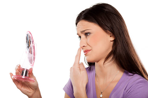 istock woman looking at herself in the mirror 467907328