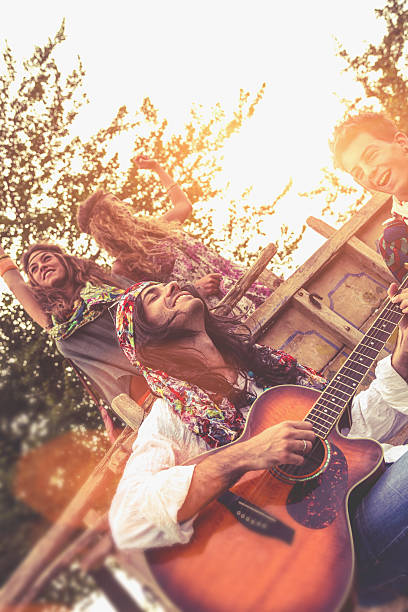 istock Hippie group playing guitar and dancing together 467909423