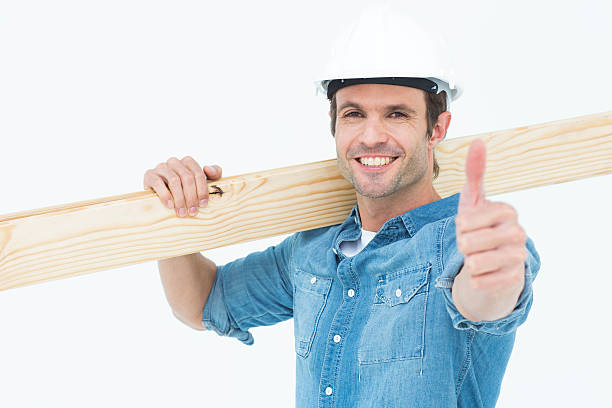 istock Confident carpenter carrying wooden plank 467913000