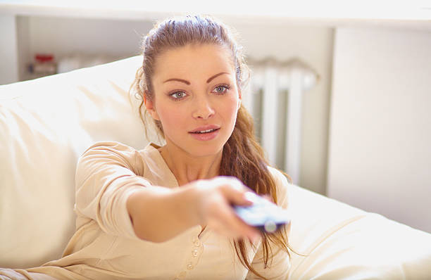 istock Young woman switches tv channels 467915219