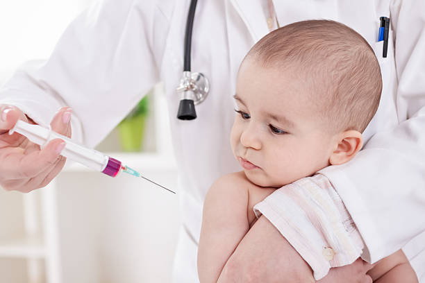 femmina medico facendo vaccino a little baby boy - surgical needle syringe prick injecting foto e immagini stock
