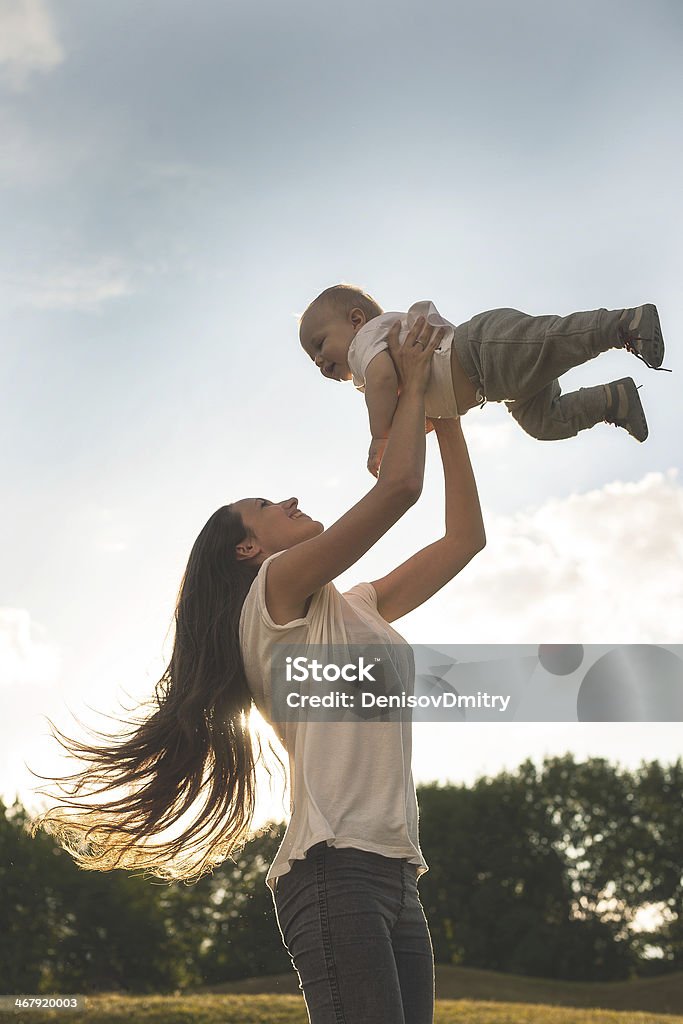 Mother with baby outdoors Beautiful mother and her son are having fun outdoors in sunshine 12-17 Months Stock Photo