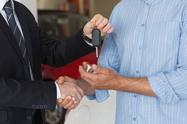 istock Businessman giving car key while shaking a customer hand 467922378