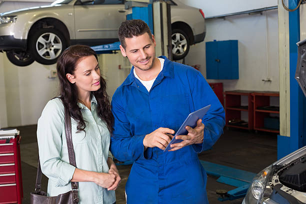 mecânico, mostrando tablet pc ao cliente - auto repair shop adult auto mechanic blue imagens e fotografias de stock
