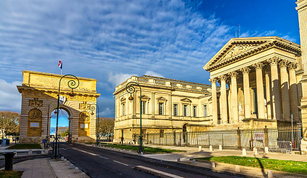 порт-peyrou и palais de справедливость в монпеллье - ancient column past arch стоков�ые фото и изображения