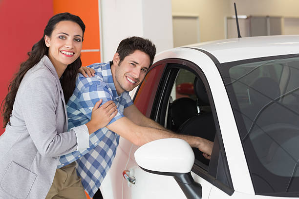 istock Smiling couple looking inside a car 467922910