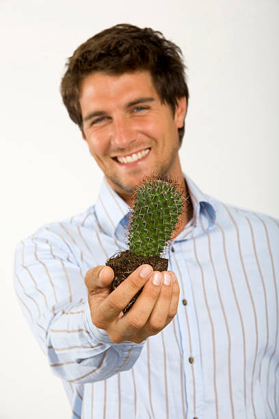 Young man holding cactus, portrait