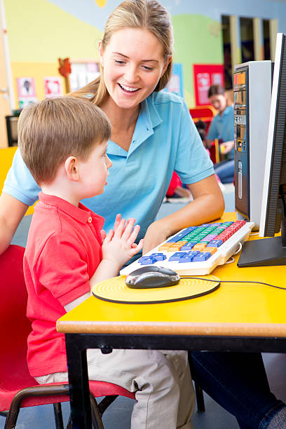 istock Preschool Boy Sitting infront of a Computer with Nursery Teacher 467924126