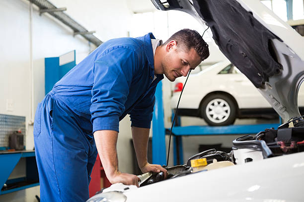 istock Mechanic examining under hood of car 467924700