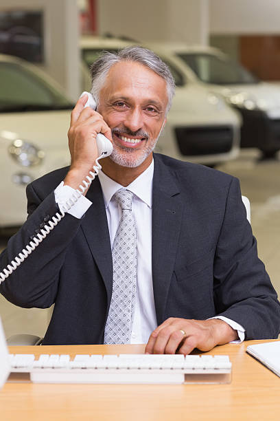 istock Smiling businessman using phone in front of computer 467925484
