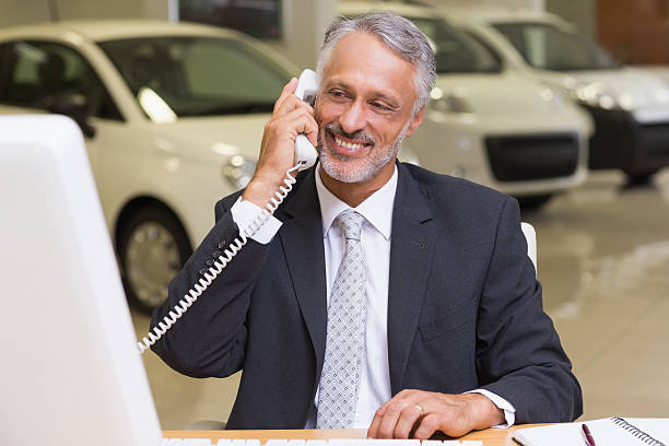 istock Smiling businessman using phone in front of computer 467925488