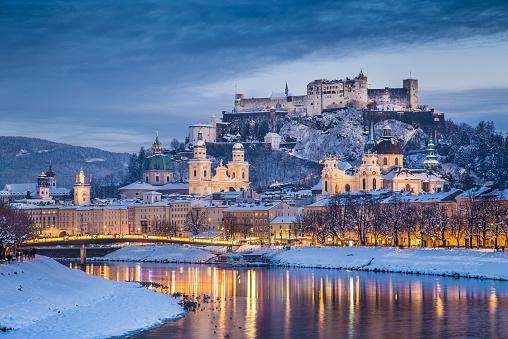 Beautiful view of the historic city of Salzburg with Salzach river in winter during blue hour, Salzburger Land, Austria.