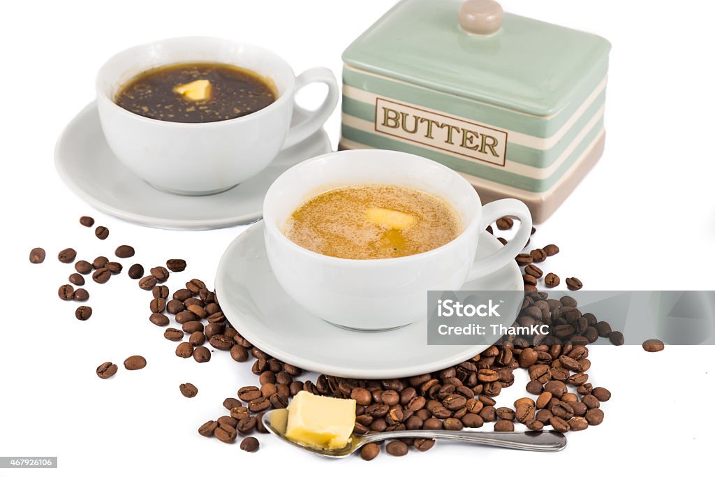 Two cups of coffee and butter, one black and one with milk Coffee with added butter, black and with milk 2015 Stock Photo