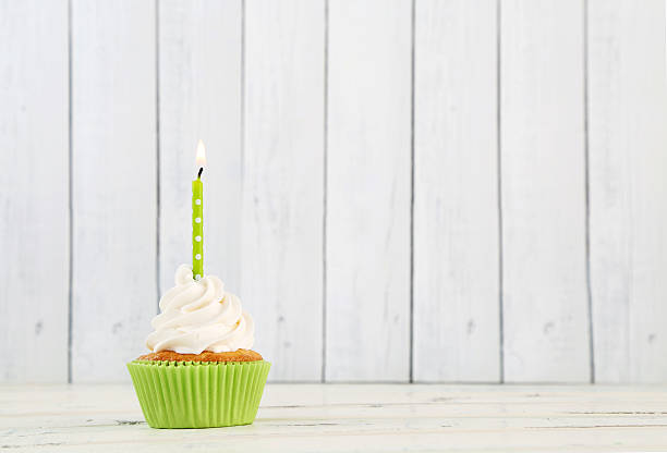 istock Lone birthday cupcake with green wrapper and candle 467926826
