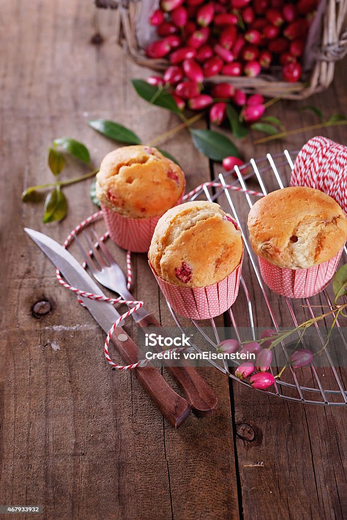 Berry muffins on a rustic dark wooden background Berry muffins with fork and knife on a rustic dark wooden background. Selective focus, shallow depth of field 2015 Stock Photo