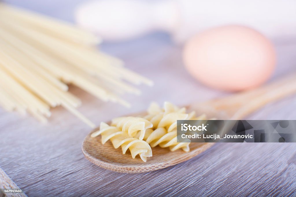 Pasta Raw macaroni on a wooden spoon 2015 Stock Photo