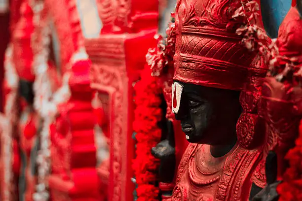 Statue of Hindu God - In direct Sunlight. Background cleaned and made black. Very slight grains in dark areas. Depth of field - focus vertically through centre of forehead